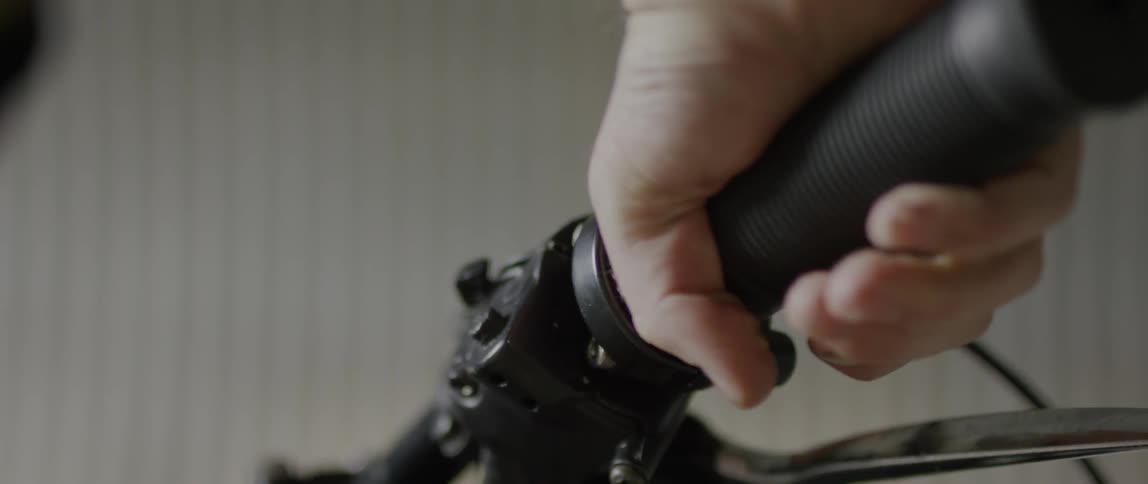 A white man with a beard turns a throttle on a motorcycle