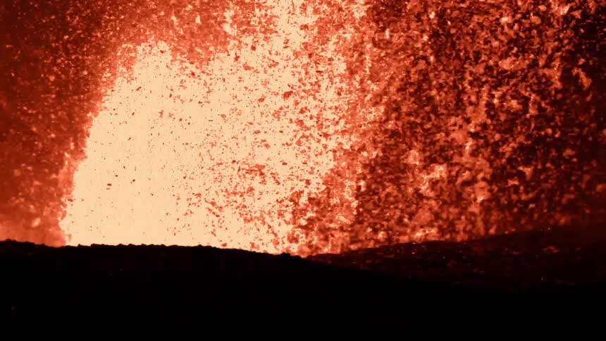 Lava explodes and splashes at night