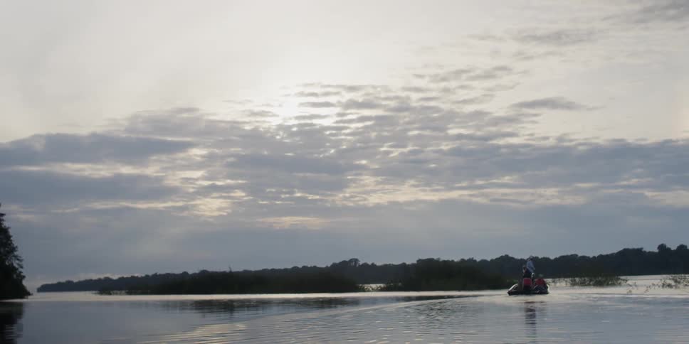 People fish from a boat on the water