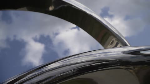 Clouds hang above a chrome structure