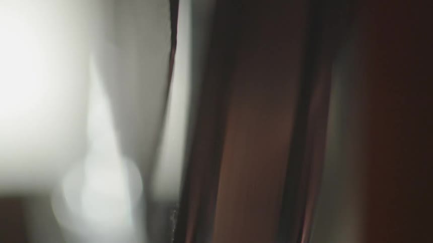 The metal wheel is spinning by a window