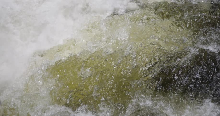 Rapids are rushing over a ledge in a river in daylight
