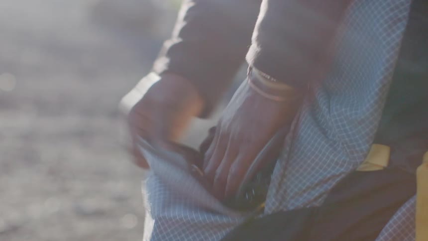 Person is putting rope in pocket of backpack
