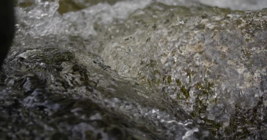 Water splashes and flows rapidly over rocks