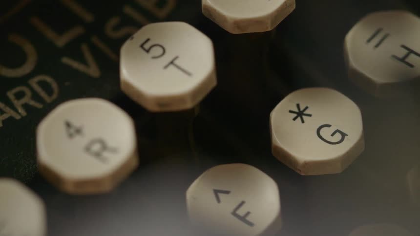 The typewriter has many keys with symbols and letters