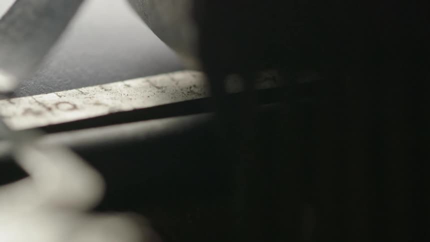 A machine  sews fabric along a ruler line