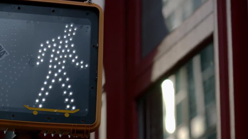 A crosswalk sign changes from stop to cross