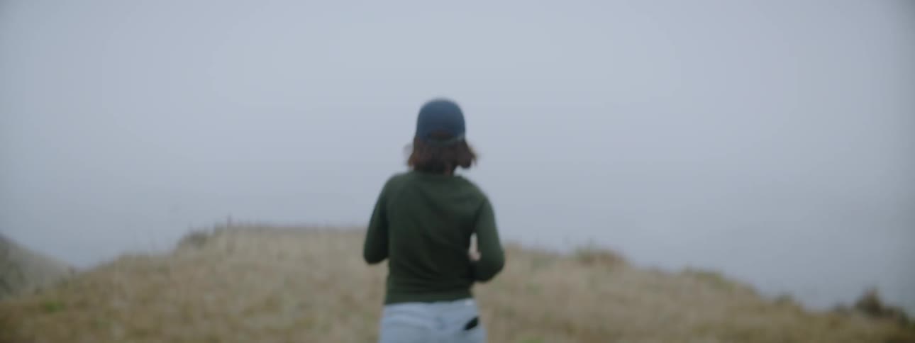 A woman is running towards the cliff