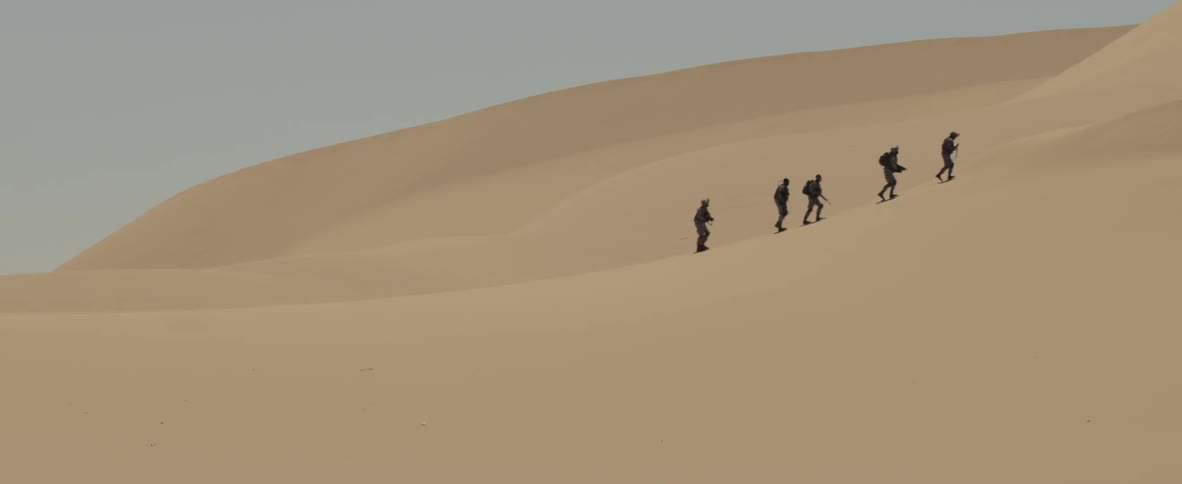 Soldiers march through the sand