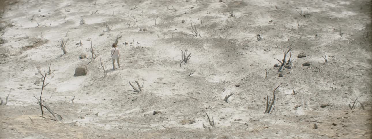 A photographer walks in a desert