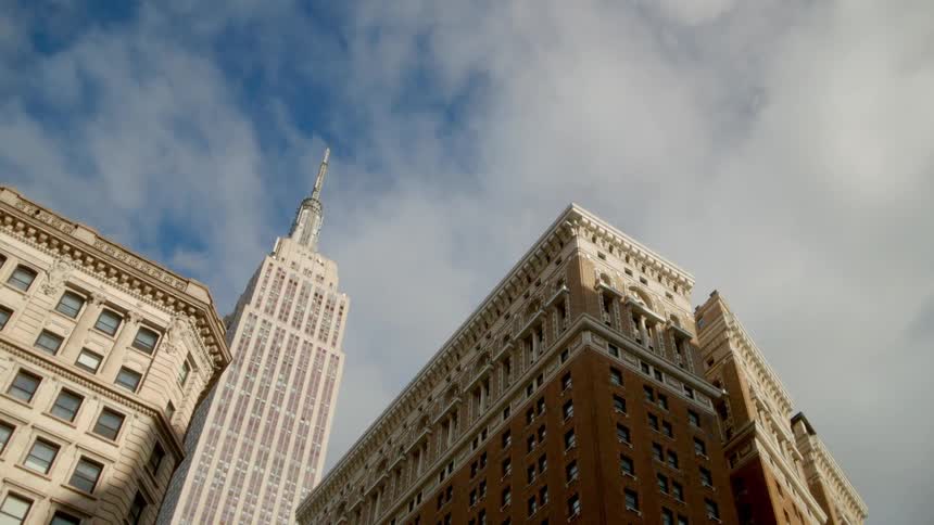 The clouds move slowly over the tall buildings