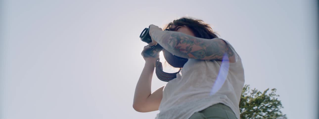 Woman takes pictures with a large camera on a sunny day
