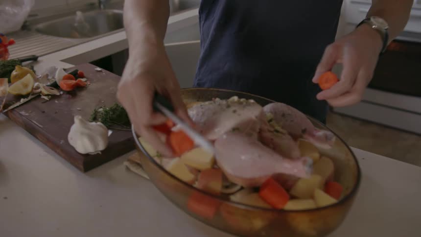 A man is preparing a chicken putting vegetables in the pan