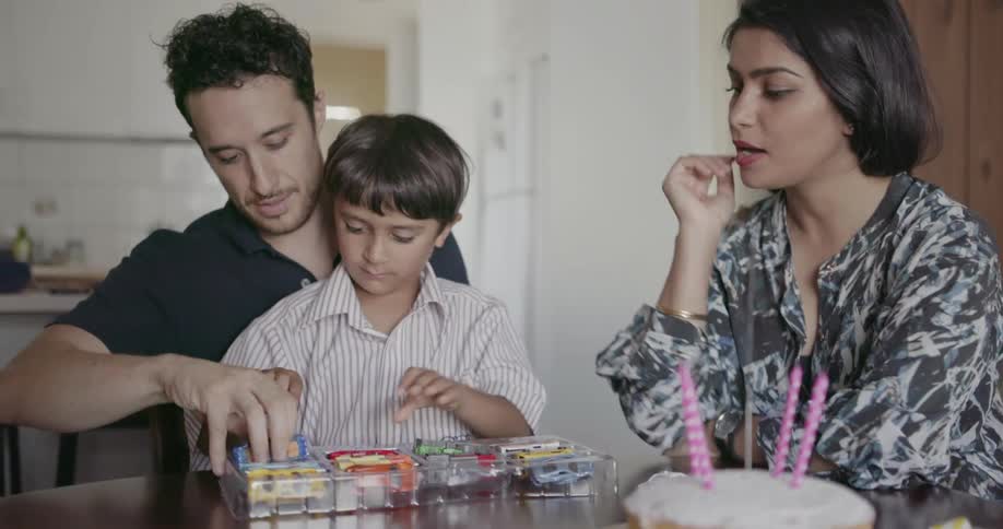 A mother, father and child celebrate a birthday