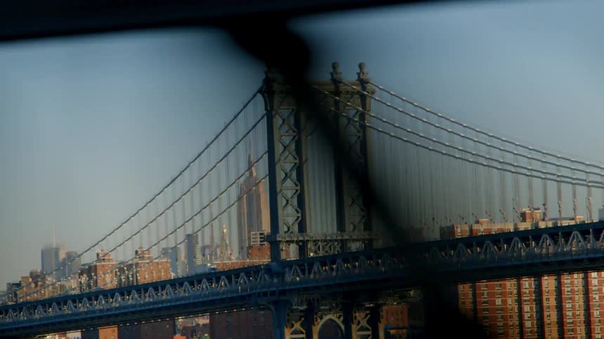 Traffic driving on bridge in a large city with many buildings