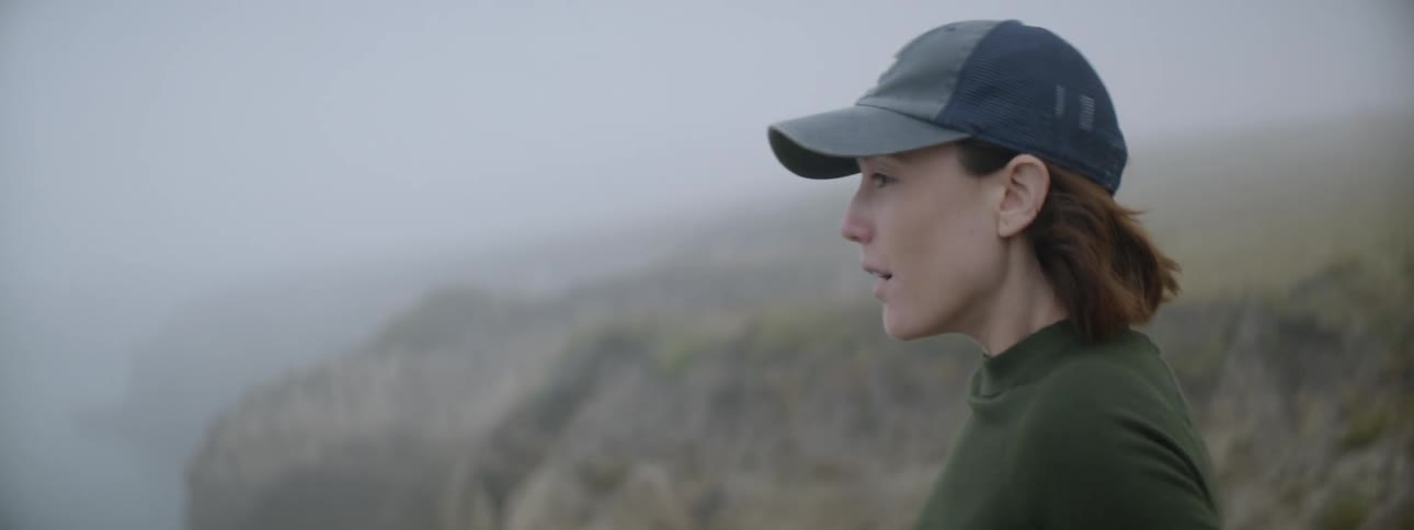 Woman takes pictures of hills with a camera on a cloudy day
