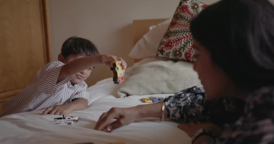 A child is playing with toys on the bed