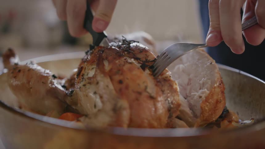 A person carves cooked poultry