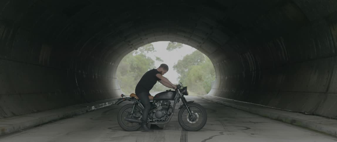 Man walking in a tunnel to his motorcycle