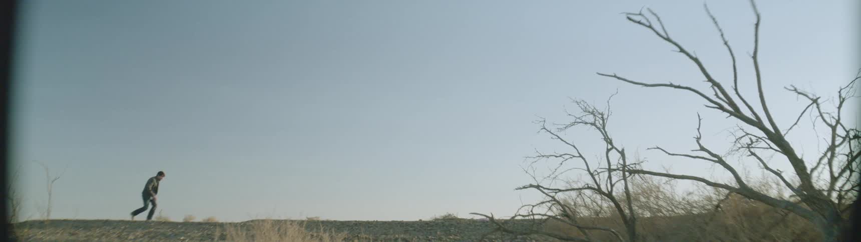 The long field is barren on a sunny day