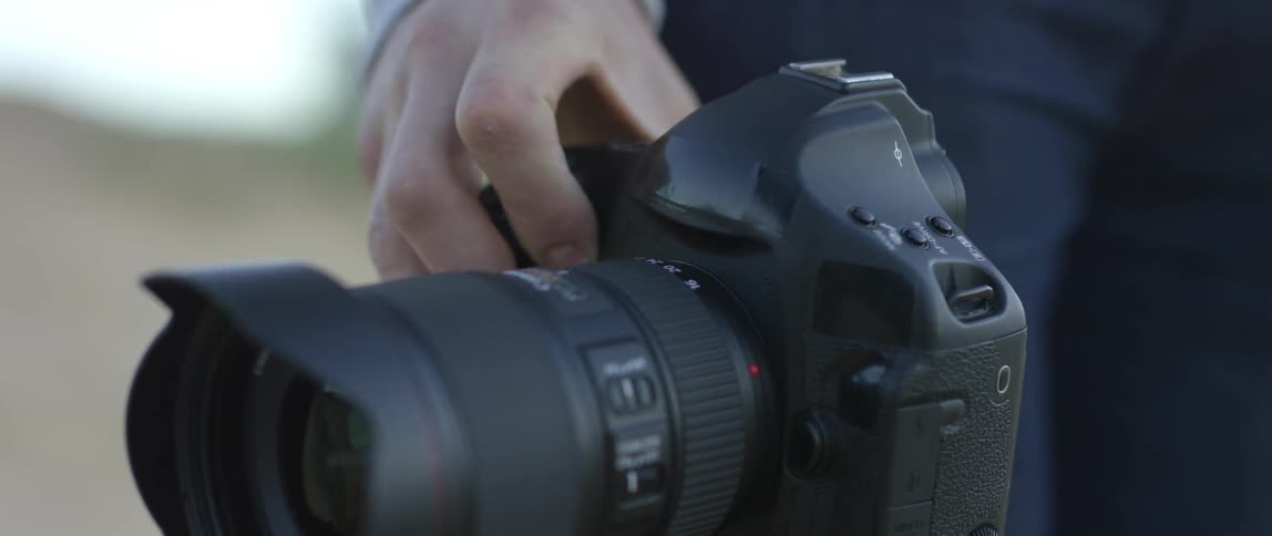 Close up of a hand on a large camera