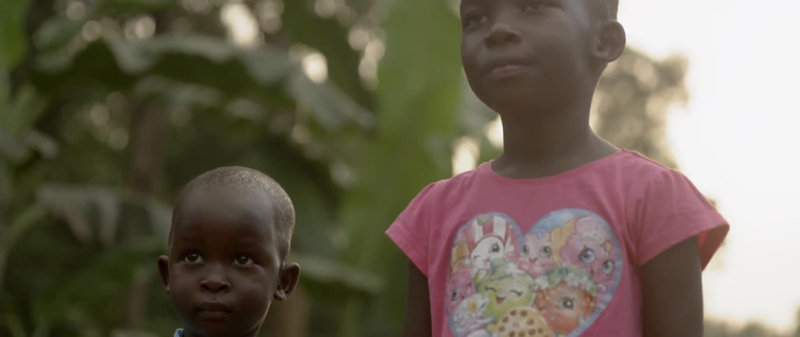 A young boy and girl hold hands outside