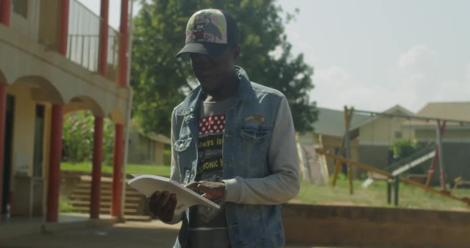 A man reads from a packet of papers outside