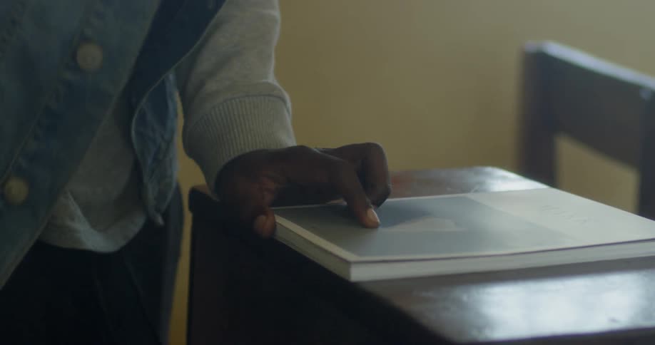 A man walks to a desk and sits down