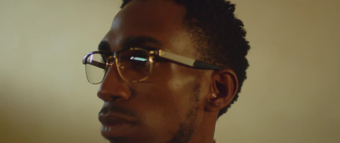 A man wearing glasses stares to the side