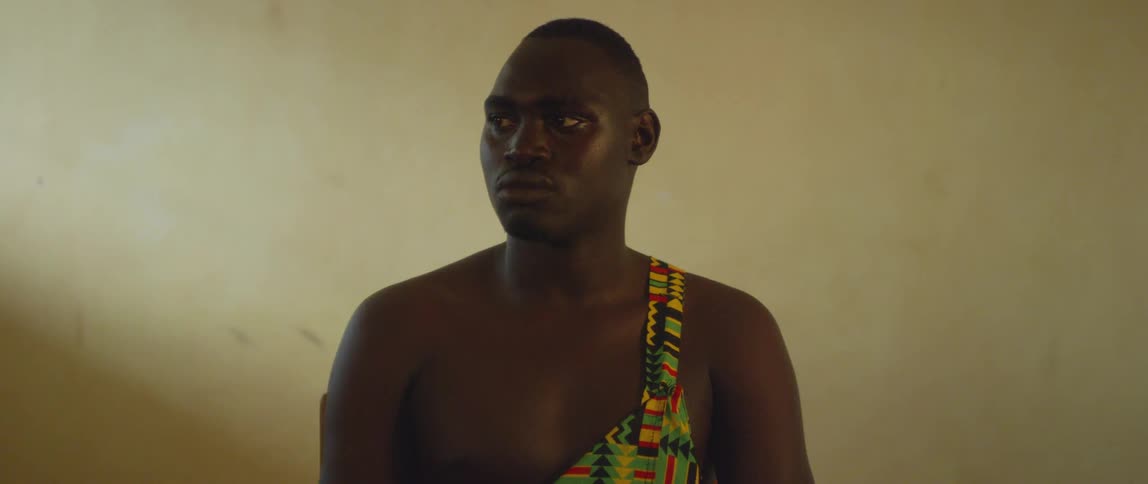 A man sits indoors and stares off to the side