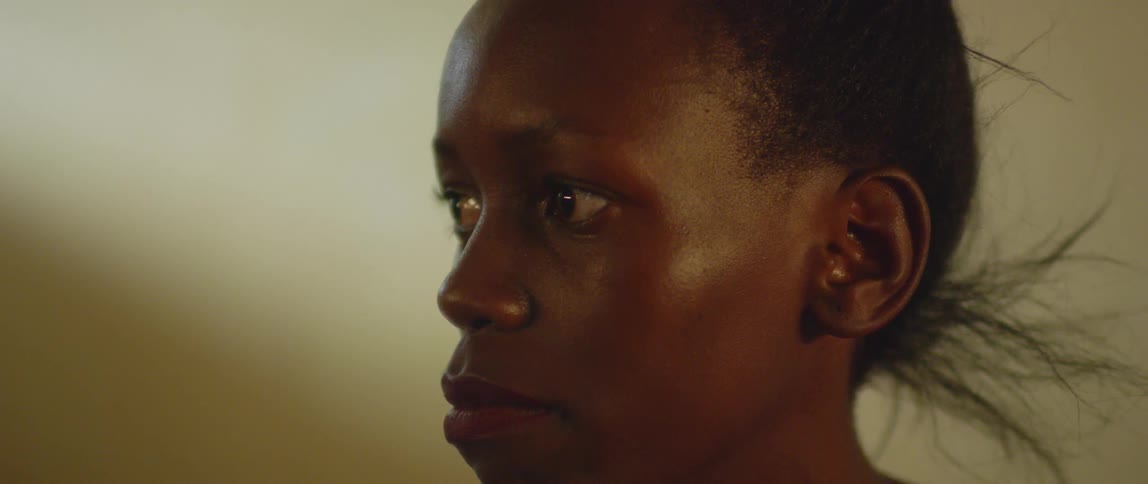 An african woman is sitting and staring into the distance in daylight