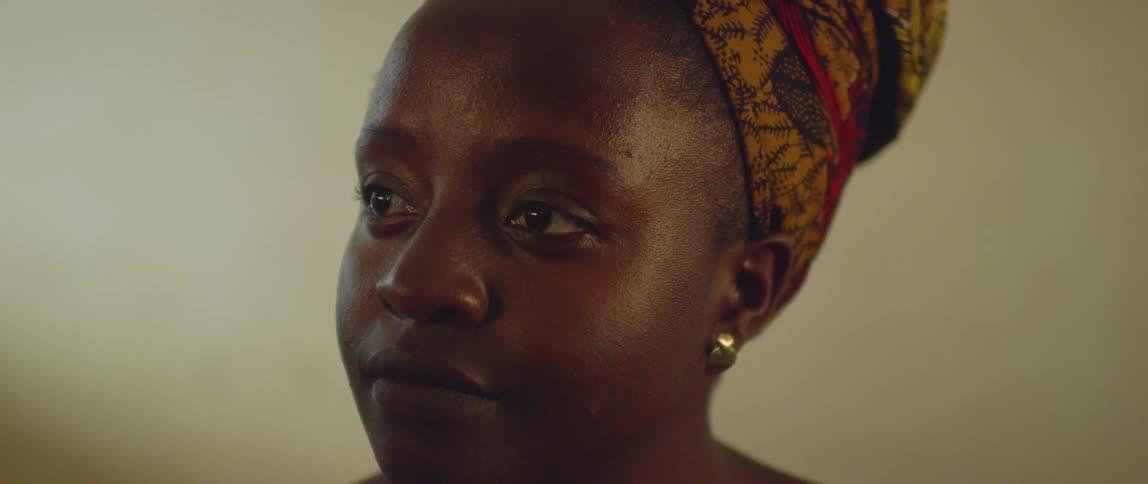 A woman wearing a headdress stares to the side