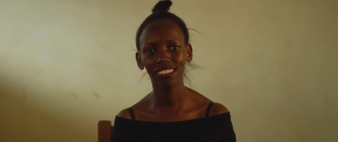 A woman smiles while sitting in a chair