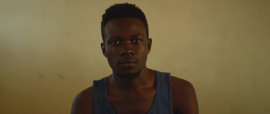 A man in a tank top stares forward