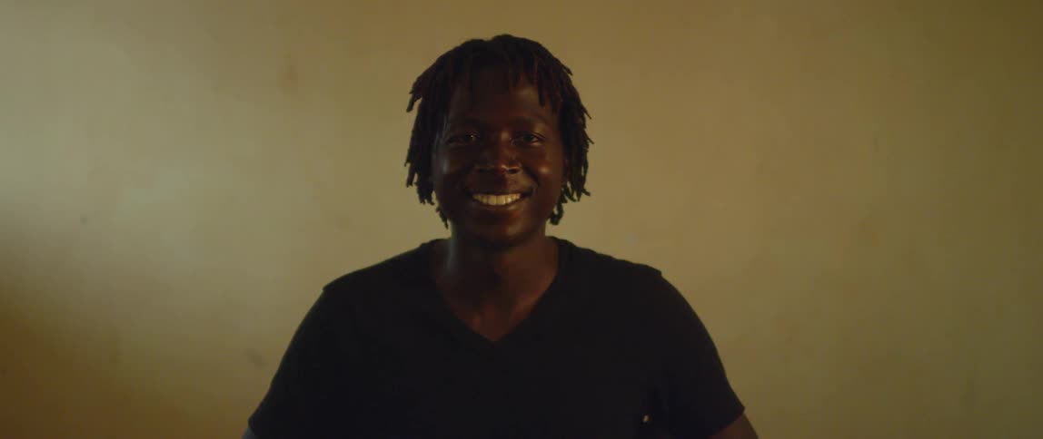 A person smiles and stares forward