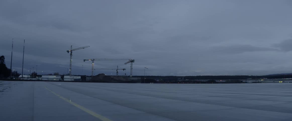 The long parking lot leads to a worksite on a cloudy day