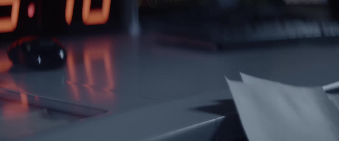 A piece of paper drops down onto a desk