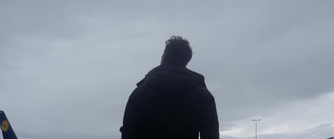 Someone is standing on the runway of an airport looking at planes