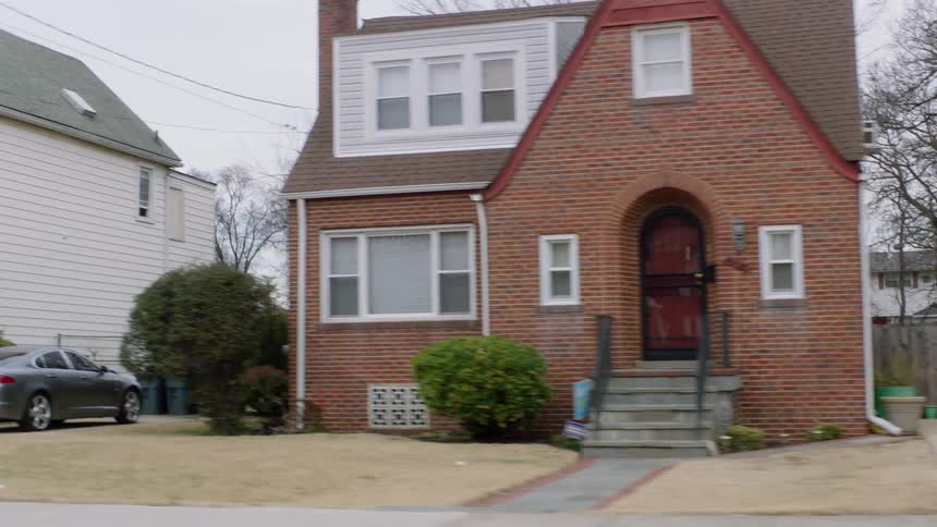 A car drives on a residential street