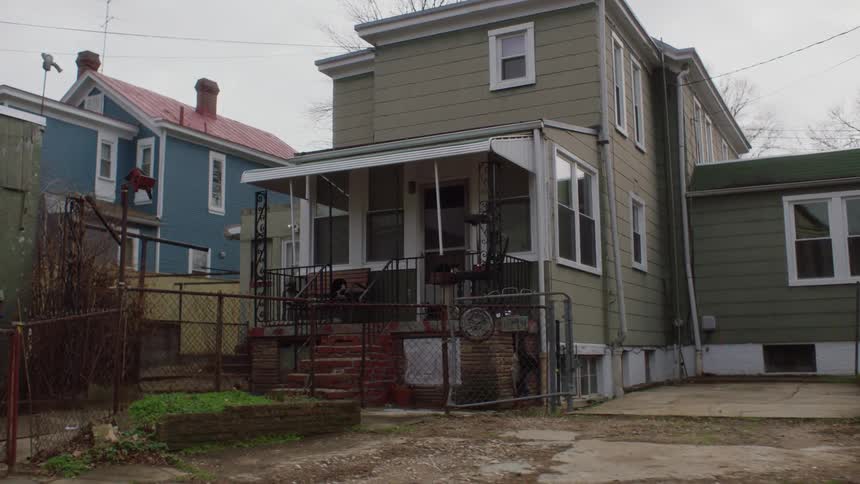 A urban city neighborhood house with a roof covered porch