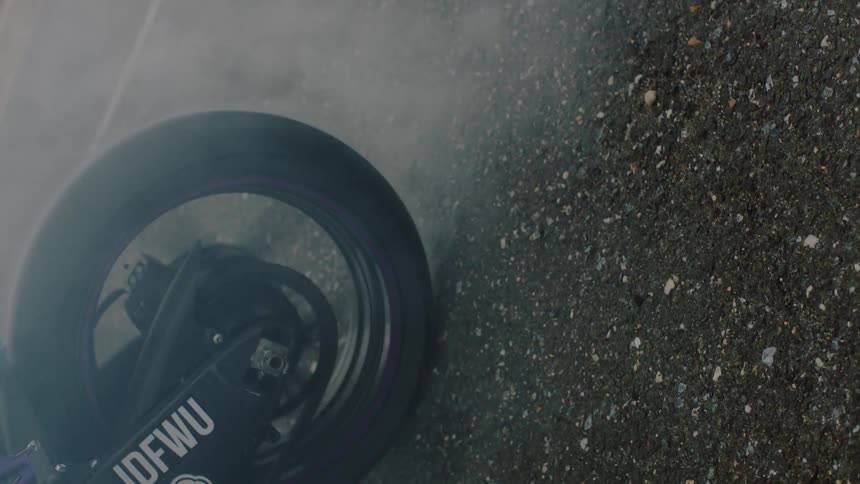A motorcycle is doing a burnout on the street