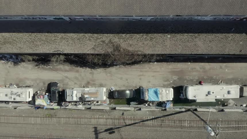 Campers and rvs parked next to railroad tracks