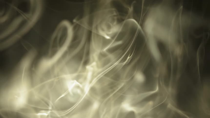 Wisps of smoke are rising and swirling in the air