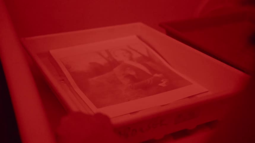 A photograph is developed in a darkroom