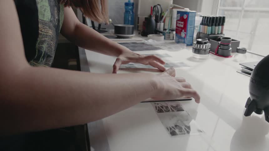 A woman affixes a backing onto a picture frame