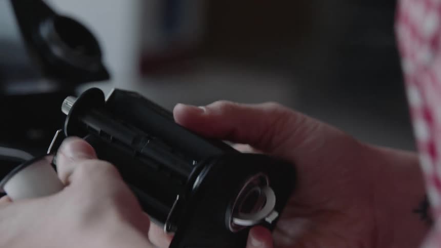 A woman loads film into a camera