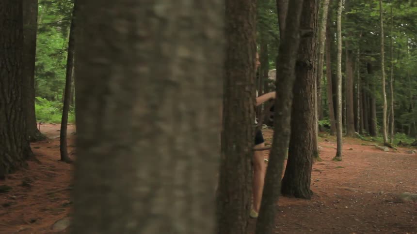 A man and woman hike through the woods