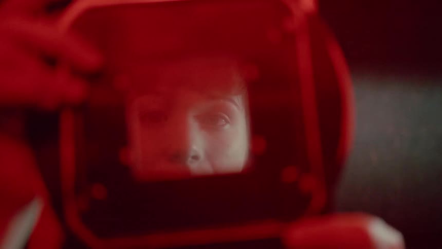 Person looks through a frame and glass