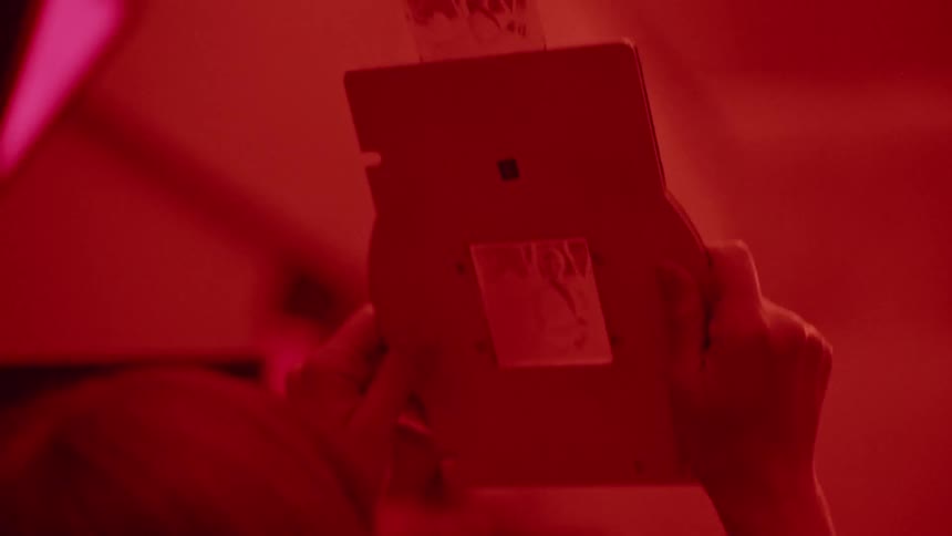 A person is examining a negative in a developing room