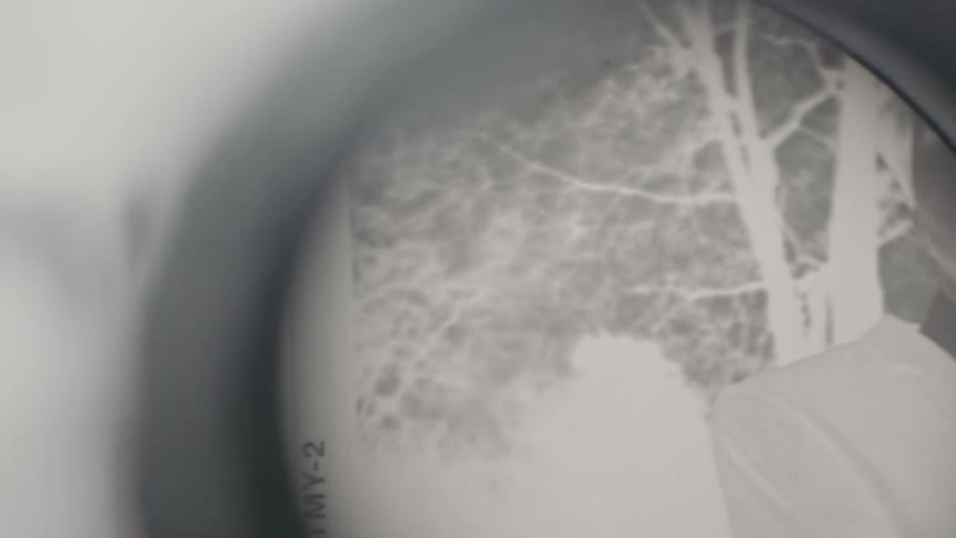 A film negative is viewed through a lens